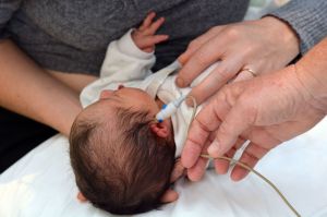 A newborn baby is screened for signs of hearing loss.