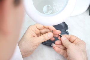 Hearing professional repairing hearing aid