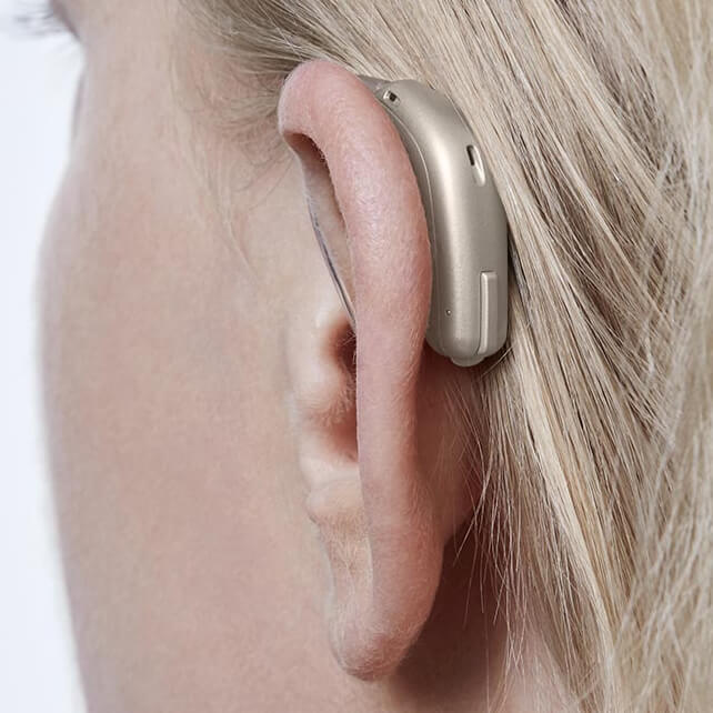 A woman with a beige hearing aid.