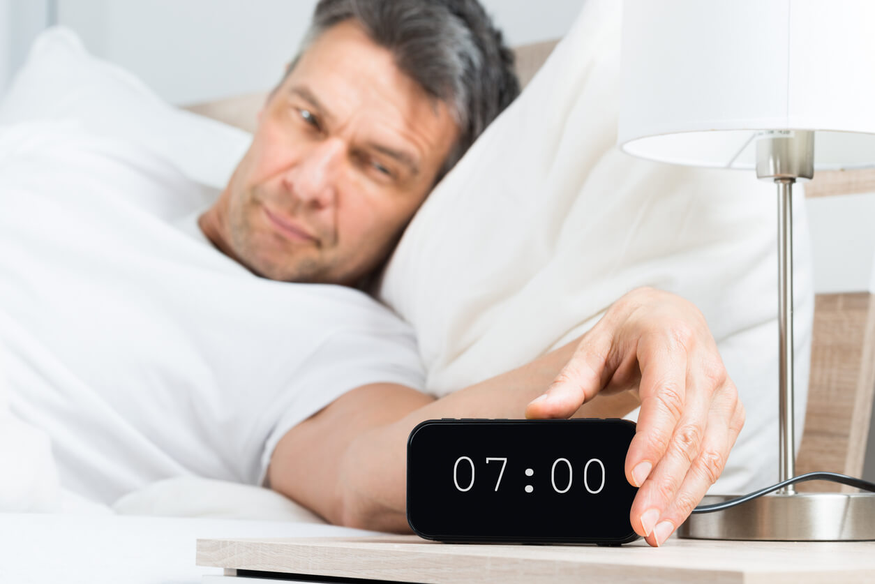 Man waking up to extra-loud alarm clock