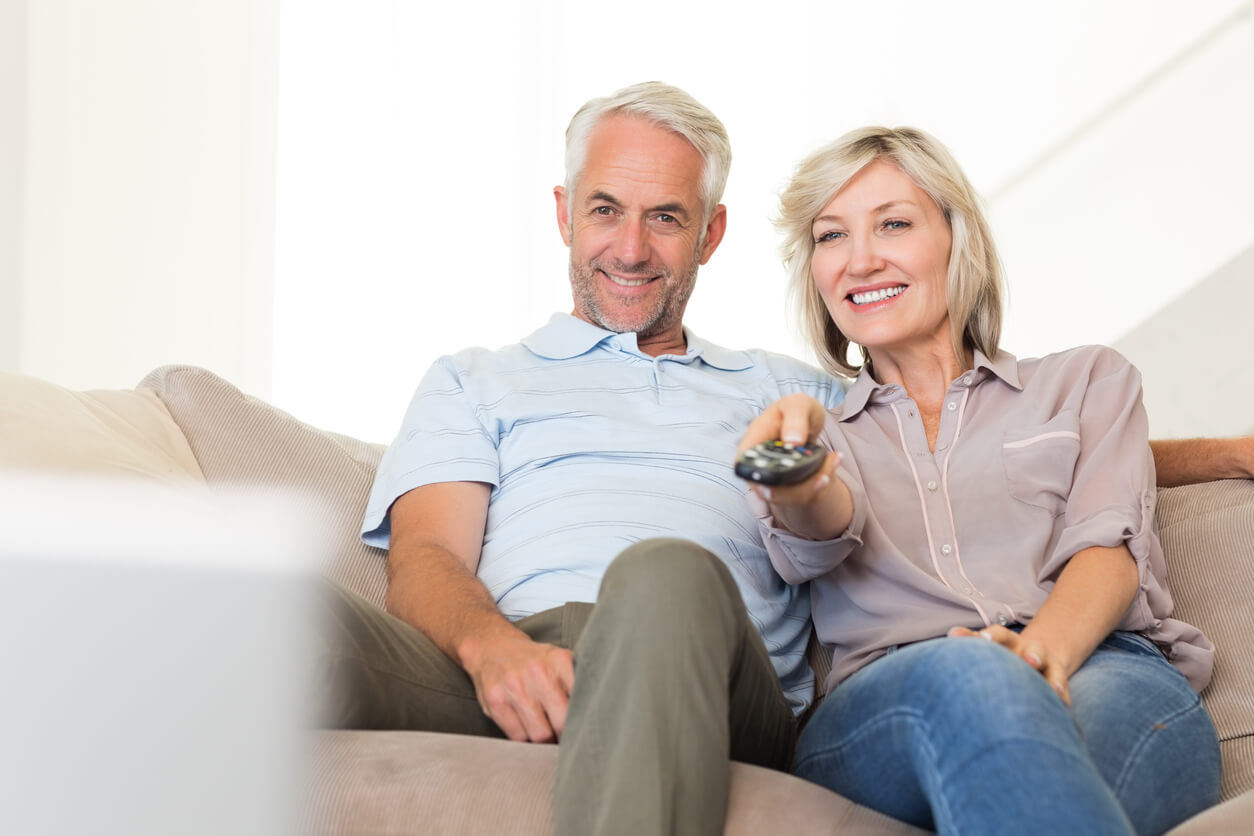 Couple watching tv with hearing aids and tv streamer