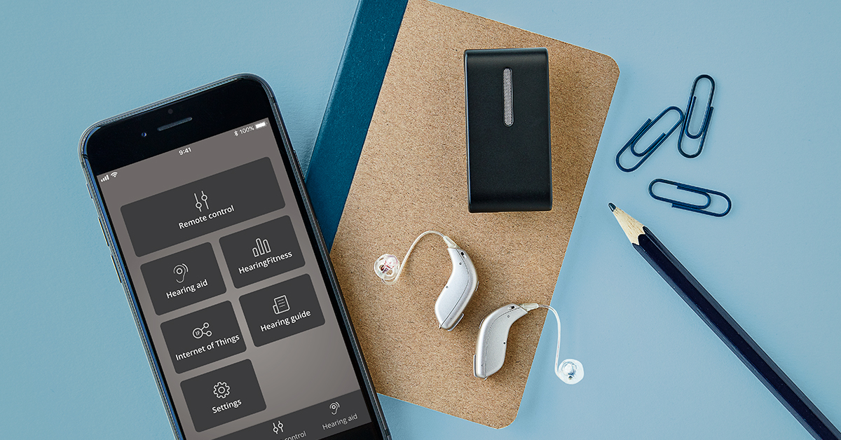 Hearing aids and smartphone app on a table.