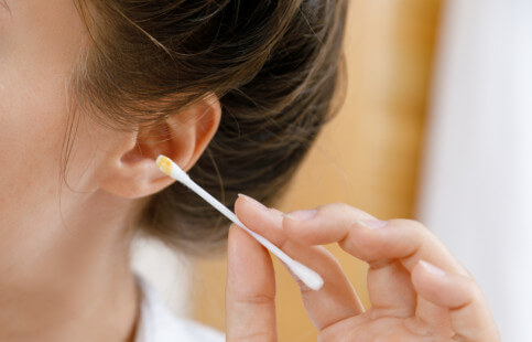 Woman holding cotton swab with earwax